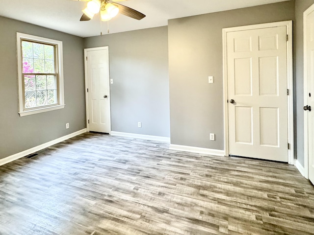 spare room with ceiling fan, wood finished floors, and baseboards