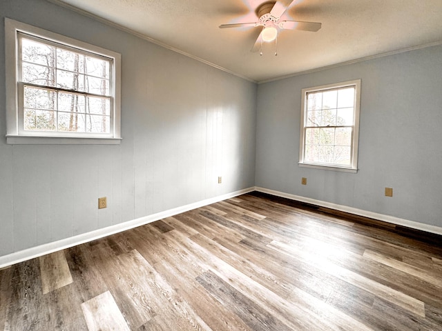 empty room with hardwood / wood-style floors, ceiling fan, and crown molding