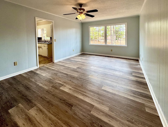 empty room featuring hardwood / wood-style flooring, ceiling fan, and crown molding