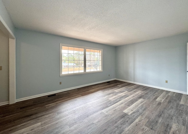 spare room with a textured ceiling and hardwood / wood-style flooring