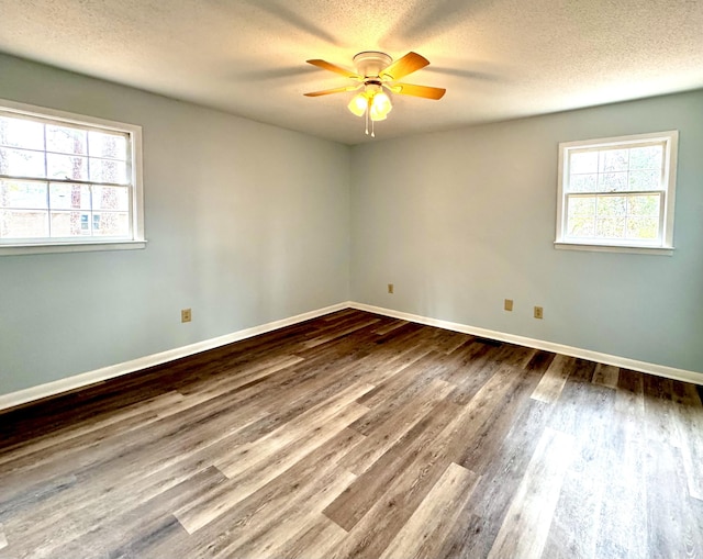 unfurnished room with ceiling fan, a healthy amount of sunlight, a textured ceiling, and hardwood / wood-style flooring