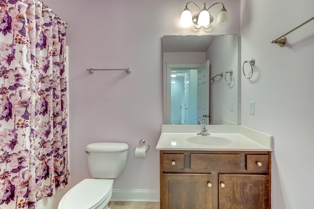 bathroom featuring vanity, toilet, and baseboards