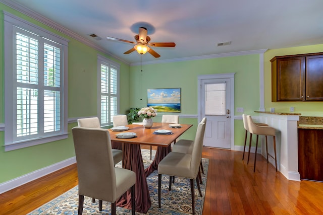 dining area featuring ornamental molding, wood finished floors, and visible vents