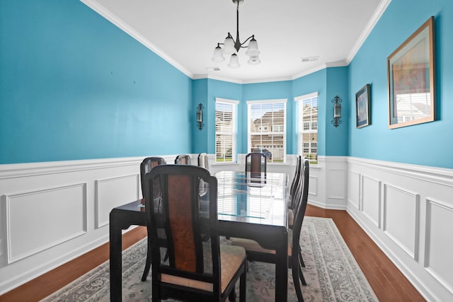 9785 Black Willow Ln, Ladson, SC 29456 - dining area with wainscoting, a chandelier, dark wood finished floors, crown molding, and a decorative wall