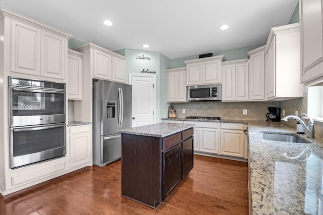 9785 Black Willow Ln, Ladson, SC 29456 - kitchen featuring stainless steel appliances, a sink, tasteful backsplash, dark wood-style flooring, and light stone countertops