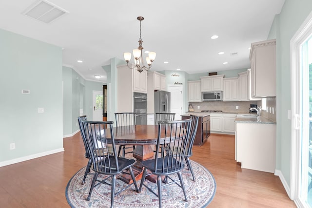 9785 Black Willow Ln, Ladson, SC 29456 - dining area with light wood-style flooring, healthy amount of natural light, a chandelier, baseboards, and recessed lighting