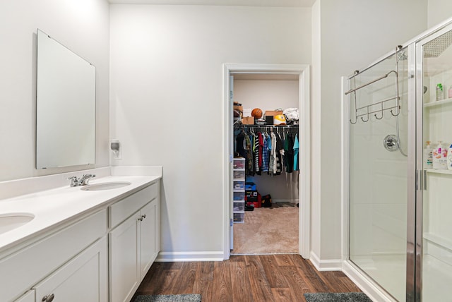 bathroom featuring a shower with shower door, wood-type flooring, and vanity