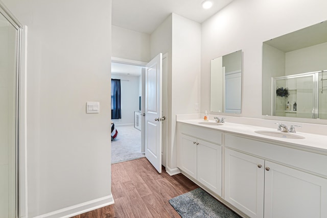 bathroom featuring wood-type flooring, vanity, and a shower with shower door