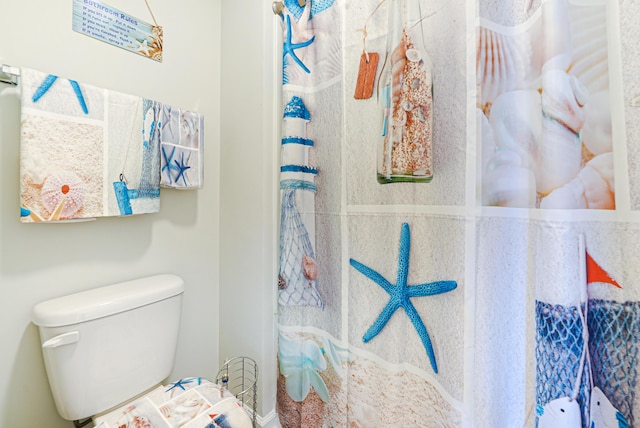 bathroom with a shower with curtain and toilet