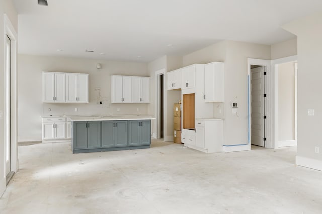 kitchen featuring white cabinets, washer / dryer, a center island, and gray cabinets