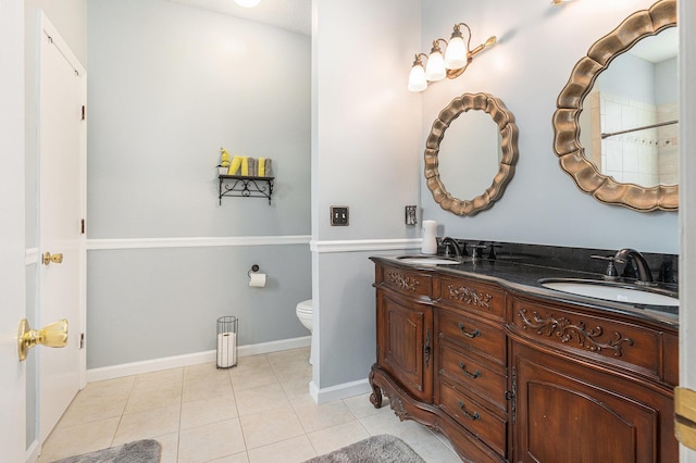 bathroom featuring double vanity, tile patterned flooring, a sink, and toilet