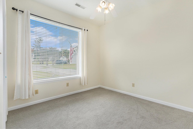 spare room with ceiling fan, carpet floors, visible vents, and baseboards