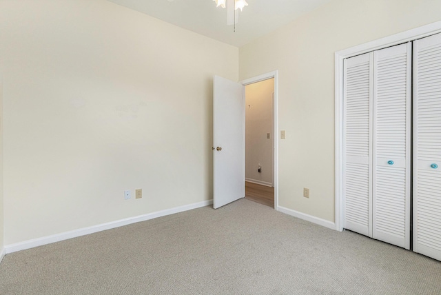 unfurnished bedroom featuring baseboards, a closet, and light colored carpet