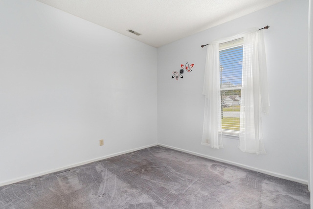 unfurnished room featuring carpet, visible vents, a textured ceiling, and baseboards