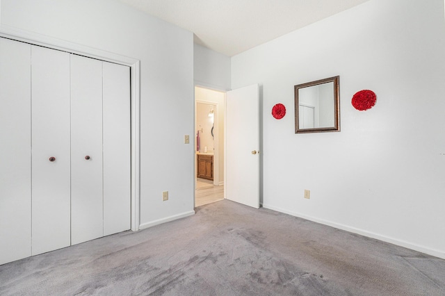 unfurnished bedroom featuring a closet, light colored carpet, and baseboards