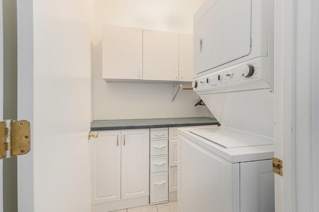 clothes washing area featuring cabinet space and stacked washer / drying machine