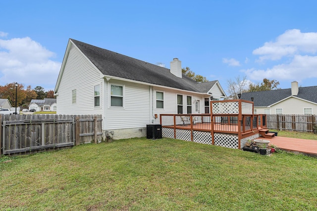 rear view of property with a fenced backyard, a lawn, a deck, and central AC unit