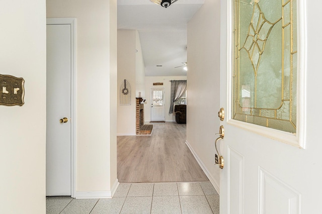 foyer with a ceiling fan, light tile patterned flooring, and baseboards