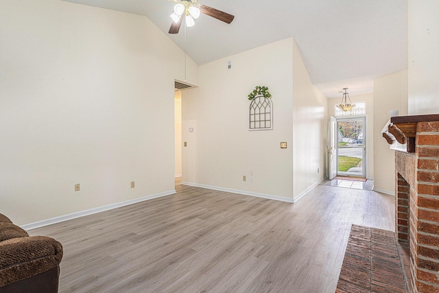 living area featuring high vaulted ceiling, ceiling fan with notable chandelier, baseboards, a brick fireplace, and light wood finished floors