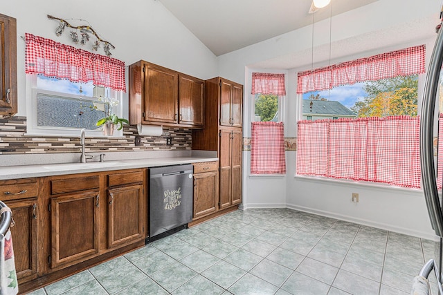 kitchen with dishwasher, lofted ceiling, backsplash, light countertops, and a sink