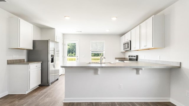 1009 Folly Rd, Summerton, SC 29148 - kitchen featuring stainless steel appliances, a peninsula, a sink, and wood finished floors