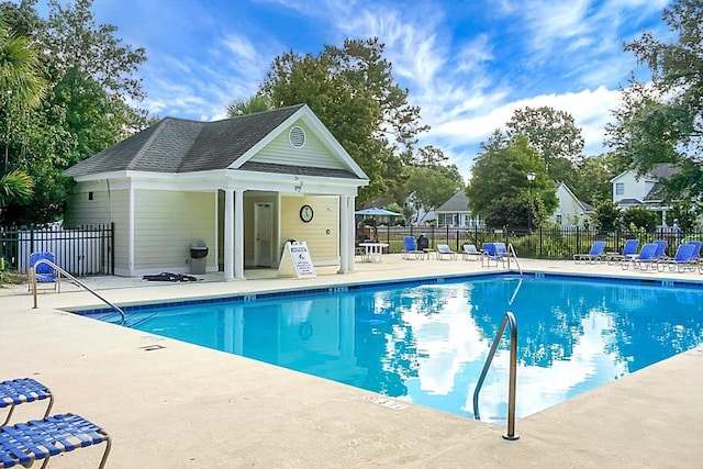 view of pool with a patio and an outdoor structure