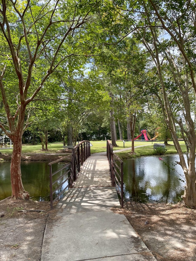 surrounding community featuring a playground and a water view