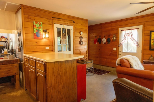 kitchen with ceiling fan and wooden walls