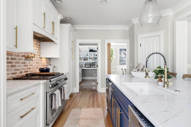 1635 Bull Creek Ln, Charleston, SC 29414 - kitchen with blue cabinets, stainless steel appliances, white cabinetry, a sink, and light wood finished floors