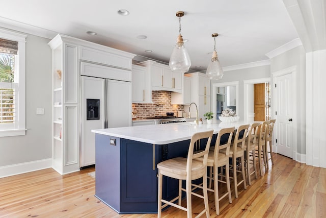 1635 Bull Creek Ln, Charleston, SC 29414 - kitchen with paneled refrigerator, decorative backsplash, light wood-type flooring, light countertops, and a large island with sink