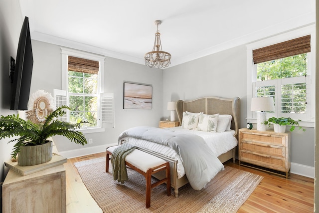 1635 Bull Creek Ln, Charleston, SC 29414 - bedroom with multiple windows, a chandelier, baseboards, light wood-type flooring, and ornamental molding
