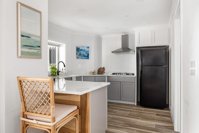 1635 Bull Creek Ln, Charleston, SC 29414 - kitchen with wall chimney exhaust hood, freestanding refrigerator, light wood finished floors, ornamental molding, and stainless steel gas cooktop