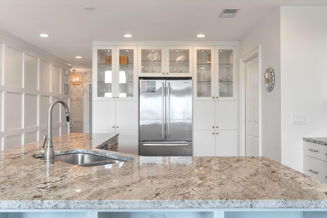 kitchen featuring white cabinetry, sink, stainless steel appliances, and light hardwood / wood-style flooring