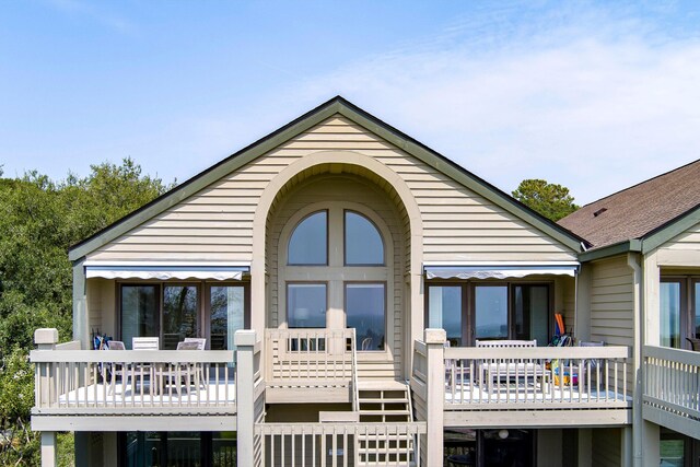 back of house with a balcony and a lawn