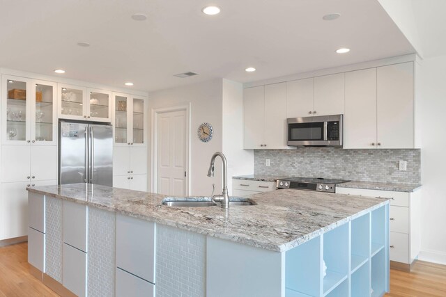 kitchen featuring white cabinetry, sink, light hardwood / wood-style flooring, and appliances with stainless steel finishes