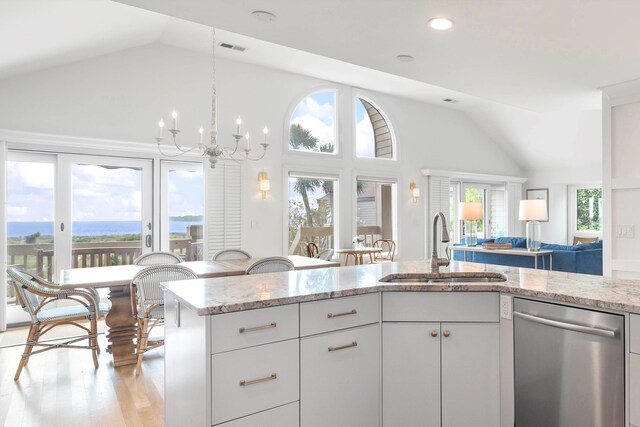 kitchen featuring an inviting chandelier, white cabinets, sink, stainless steel dishwasher, and light hardwood / wood-style floors