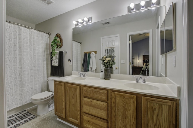 bathroom with double vanity, visible vents, a sink, and tile patterned floors