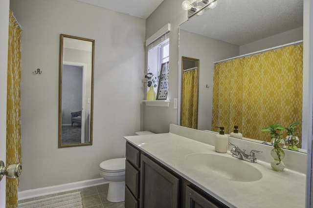 full bathroom featuring toilet, a textured ceiling, vanity, baseboards, and tile patterned floors