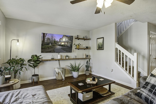 living room with a textured ceiling, stairway, wood finished floors, and baseboards