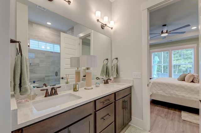 bathroom with hardwood / wood-style flooring, ceiling fan, vanity, and an enclosed shower