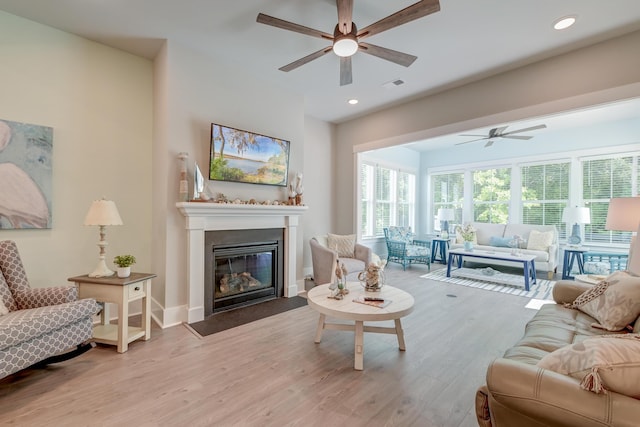 living room with light hardwood / wood-style floors and ceiling fan