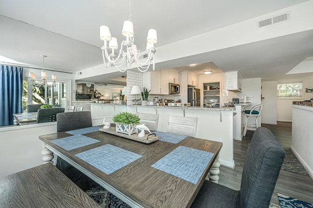 dining space with a chandelier and dark wood-type flooring