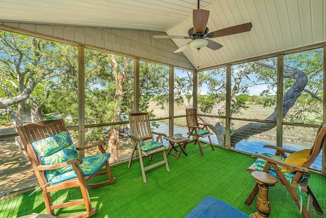 unfurnished sunroom with ceiling fan and vaulted ceiling