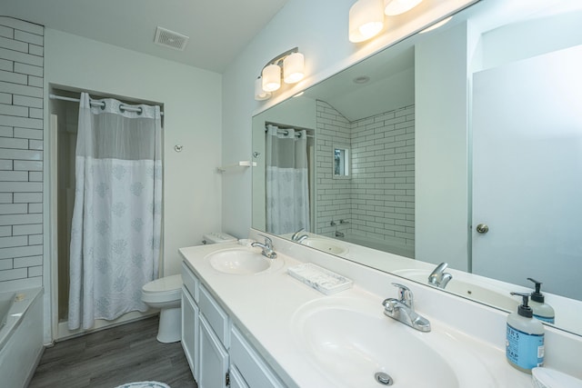 full bathroom featuring dual vanity, wood-type flooring, toilet, and shower / tub combo with curtain