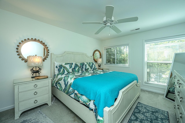 carpeted bedroom featuring multiple windows and ceiling fan