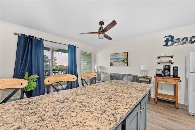 kitchen with ceiling fan, ornamental molding, light hardwood / wood-style floors, and white fridge