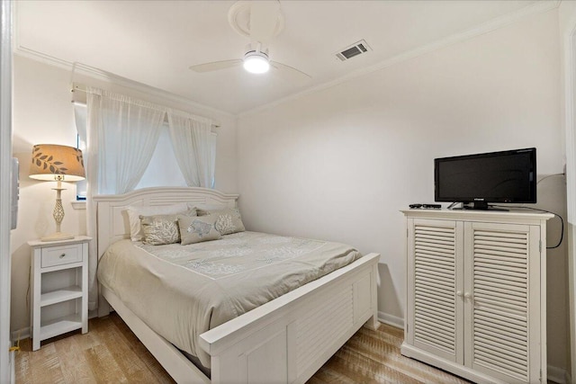 bedroom with crown molding, ceiling fan, and hardwood / wood-style flooring