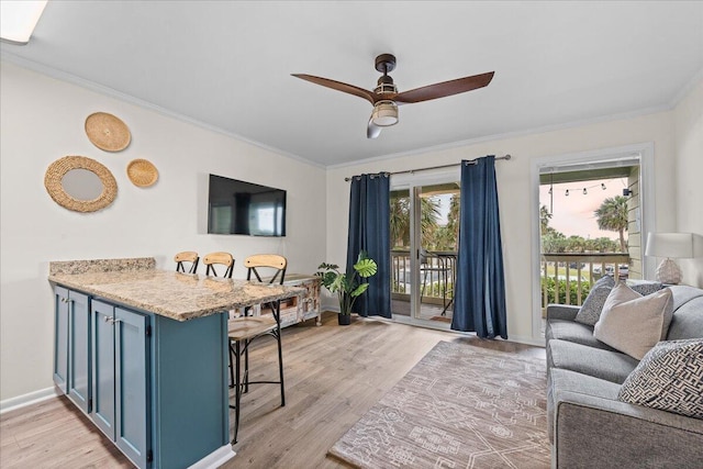 living room with light wood-type flooring, crown molding, and ceiling fan