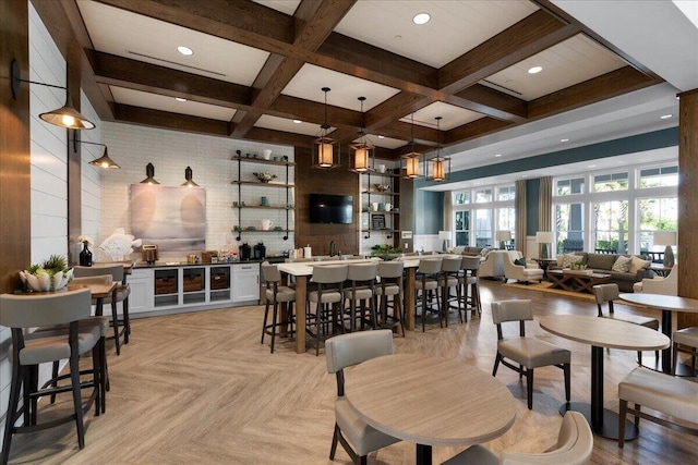 dining room featuring indoor wet bar, coffered ceiling, and beam ceiling