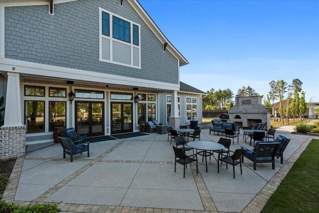 view of patio / terrace featuring french doors and an outdoor fireplace